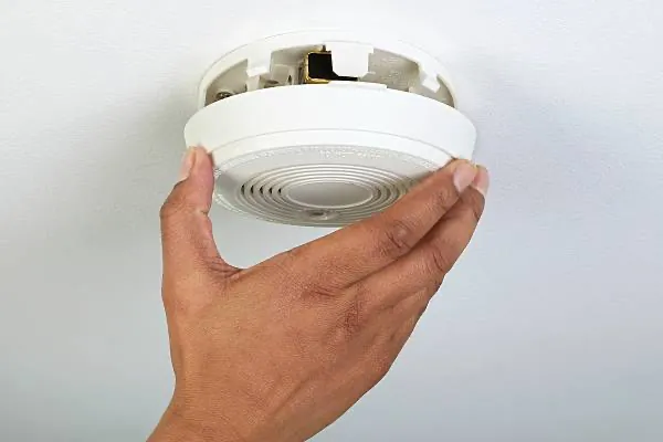 Expert technician ensuring smoke detector compliance for Melbourne commercial building